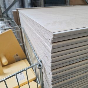 Drywall panels stacked in a London warehouse, ideal for construction projects
